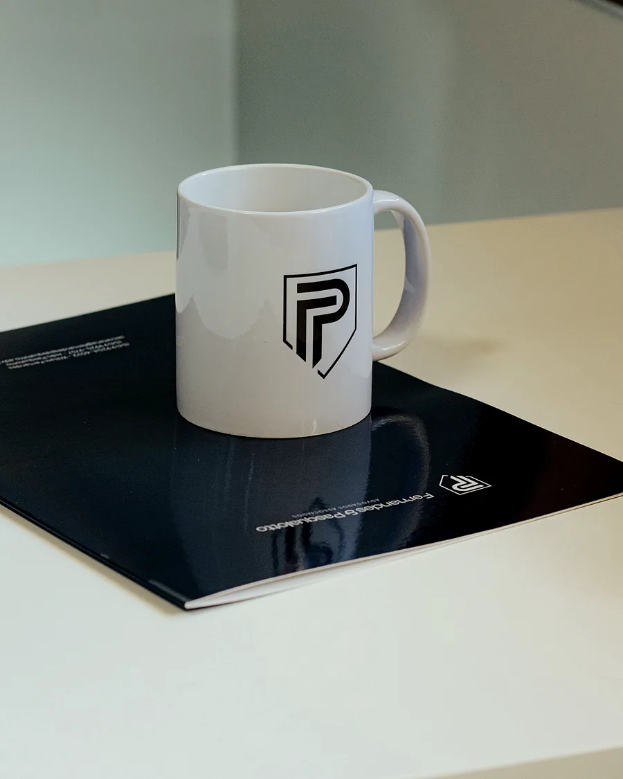 Caneca com o emblema do escritório sobre a pasta institucional